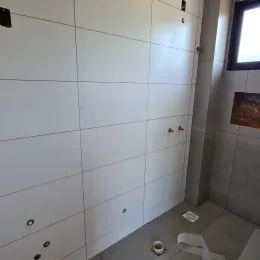 Parede branca com painéis na propriedade em Lajeado.