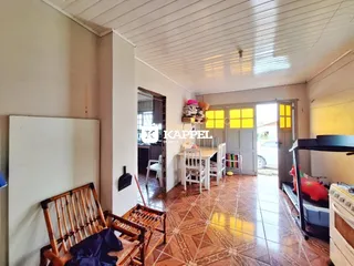 Ambiente interno com piso de cerâmica e móveis de madeira em uma sala de estar.