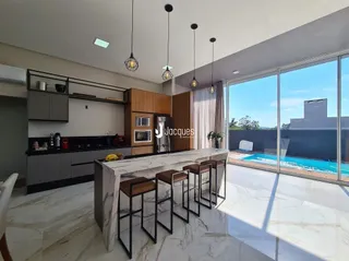 Ambiente moderno com ilha de cozinha e grandes janelas.