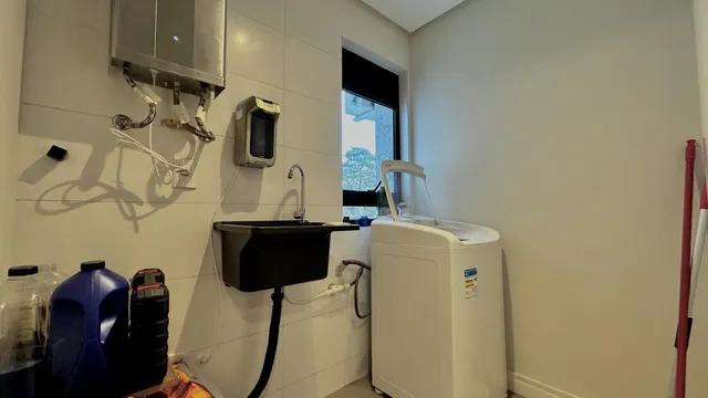 Foto de um ambiente interno mostrando uma pia e um aquecedor de água.