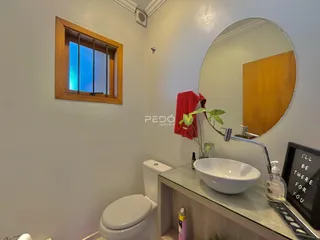 Banheiro com janela e espelho em um imóvel.