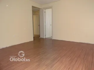 Hall de entrada com piso de madeira e paredes claras.