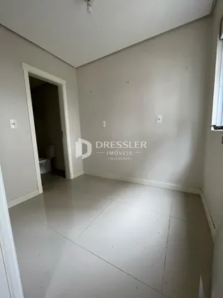 Hall de entrada com piso claro e paredes brancas.