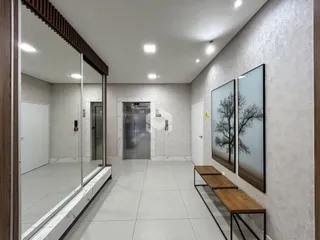 Corredor interno de um imóvel com piso de cerâmica e paredes brancas.