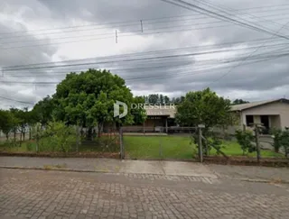 Vista externa de uma propriedade com gramado e cerca.