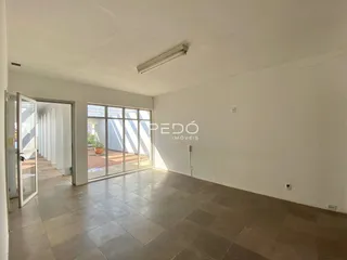 Sala de estar com piso de cerâmica e porta de vidro que dá para o exterior.