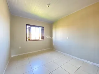 Uma sala com piso de cerâmica e janela em uma residência.