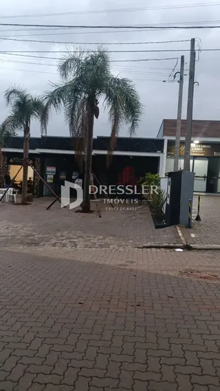 Vista da fachada de uma propriedade em Lajeado, Brasil, com árvores e pavimento na frente.
