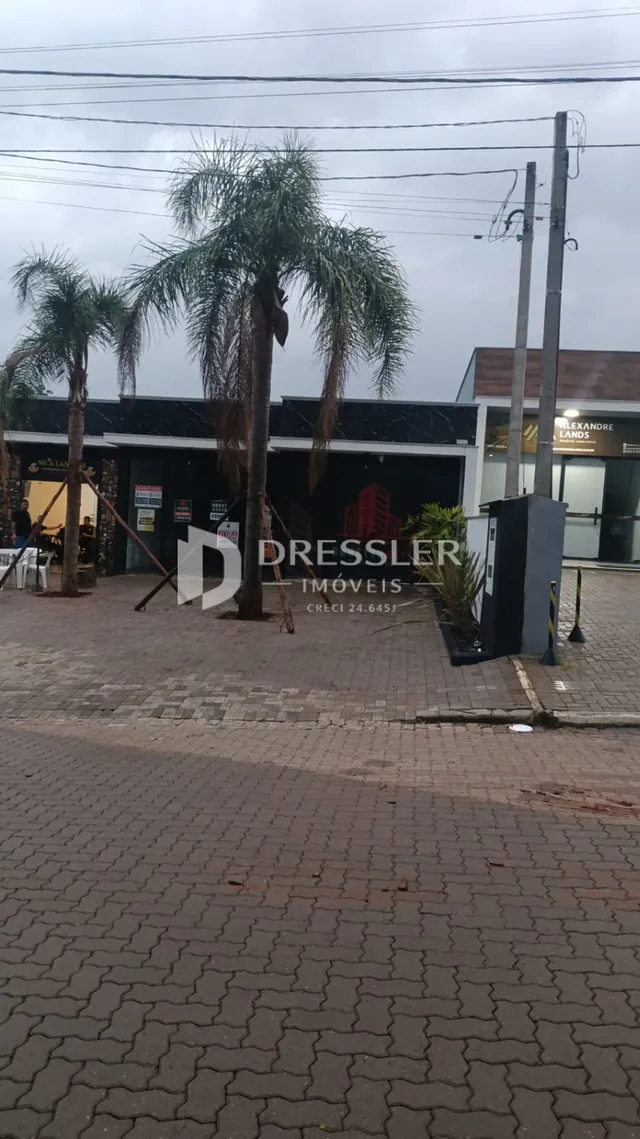Vista da fachada de uma propriedade em Lajeado, Brasil, com árvores e pavimento na frente.