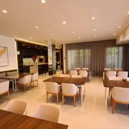 Foto interna de uma sala com teto embutido e piso de madeira.
