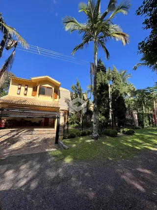 Fachada de uma residência em Lajeado, Brasil, com jardim e paisagismo.