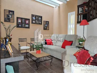 A sala de estar exibe uma parede decorada com quadros e um sofá.