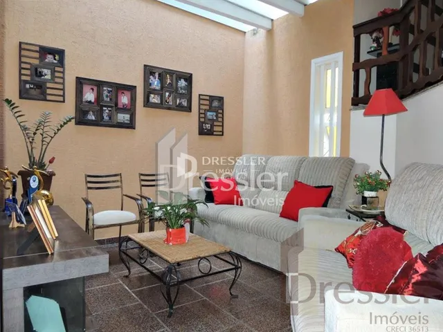 A sala de estar exibe uma parede decorada com quadros e um sofá.