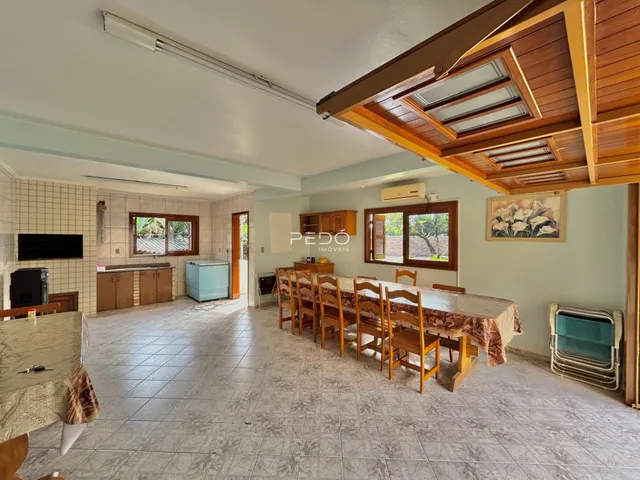 Interior de uma sala de jantar com piso de cerâmica e teto de madeira.