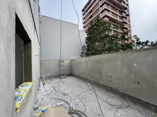 Vista externa de uma área de concreto ao ar livre entre edifícios residenciais.