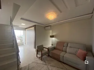 Vista de um hall com escada e sala de estar em um imóvel.