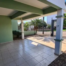 Área externa pavimentada com piso de cerâmica e estrutura de cobertura.