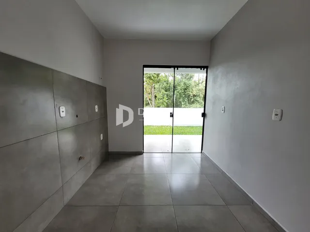 Corredor interno com piso de cerâmica e paredes cinzas.