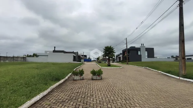 Vista da fachada de uma propriedade com paisagismo e acesso pavimentado.