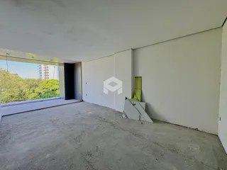 Espaço interno com piso de concreto e paredes brancas.