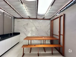 Interior de um ambiente com revestimento de mármore e móveis de madeira.