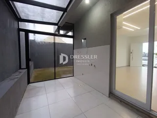 Interior de uma sala com portas de vidro que dão acesso a uma área externa.