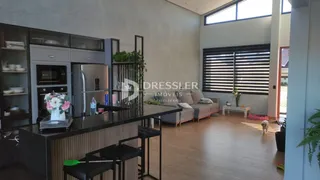 Interior de uma sala de estar com cozinha aberta em um imóvel no Brasil.