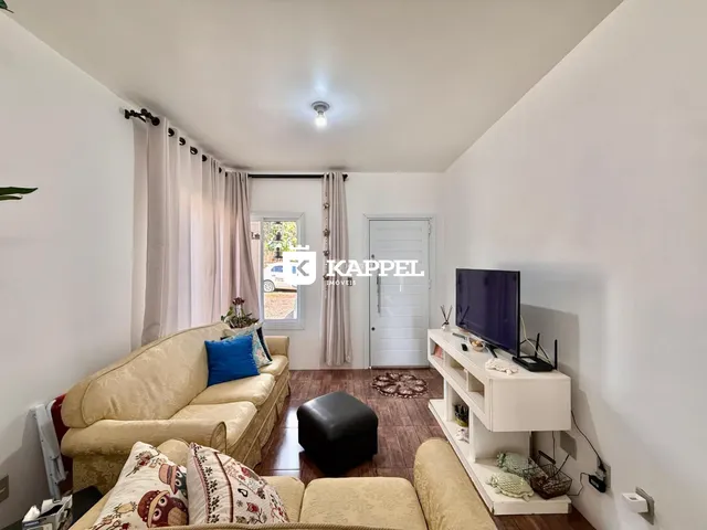 Sala de estar com sofá e televisão em um apartamento.