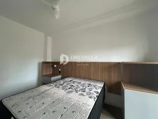 Quarto com cama e painel de madeira na parede.