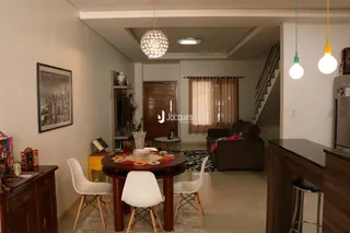 Sala de estar com mesa de madeira e cortinas.