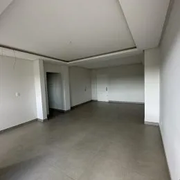 Vista interna de um ambiente com paredes brancas e piso cinza.
