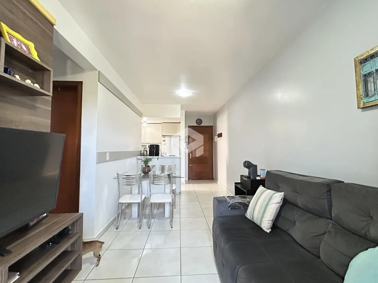 Interior de uma sala de estar com cozinha em um apartamento.