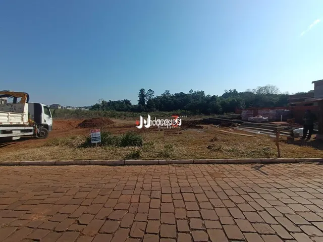 Vista externa de um terreno com pavimento de tijolos no primeiro plano.