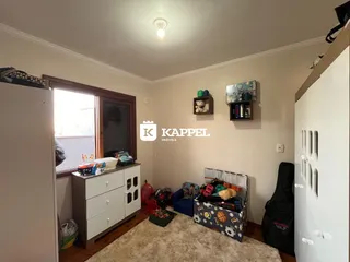 Quarto com cama e armário branco em ambiente interno.