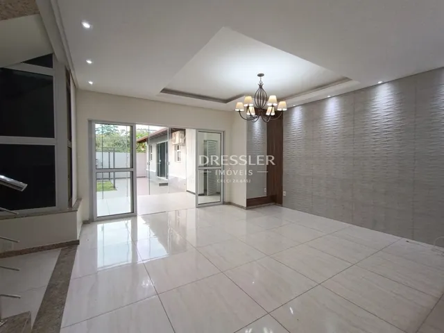 Sala de estar com piso de cerâmica e portas de vidro que dão acesso ao exterior.