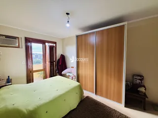 Quarto com cama e armário de madeira no imóvel.