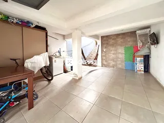 Foto de um ambiente interno com piso de cerâmica e área de cozinha.