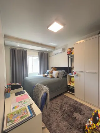 Quarto com cama e armários brancos em um apartamento.