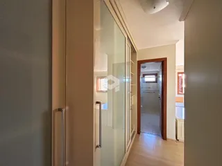 Vista de um corredor interno com portas de vidro em uma residência.