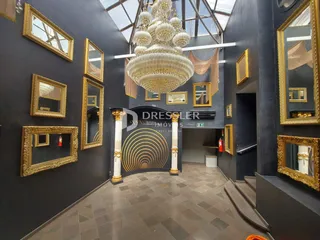 Interior de um hall com decoração dourada e lustre no imóvel.