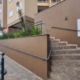 Vista externa de uma parede com escadaria em um imóvel.