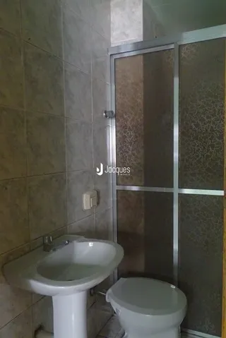 Foto de um banheiro com azulejos brancos.