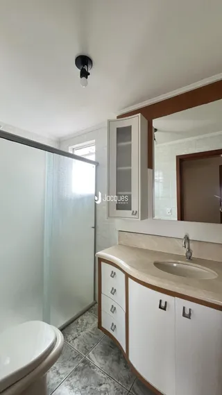 Foto de um banheiro com box de vidro e bancada de mármore.