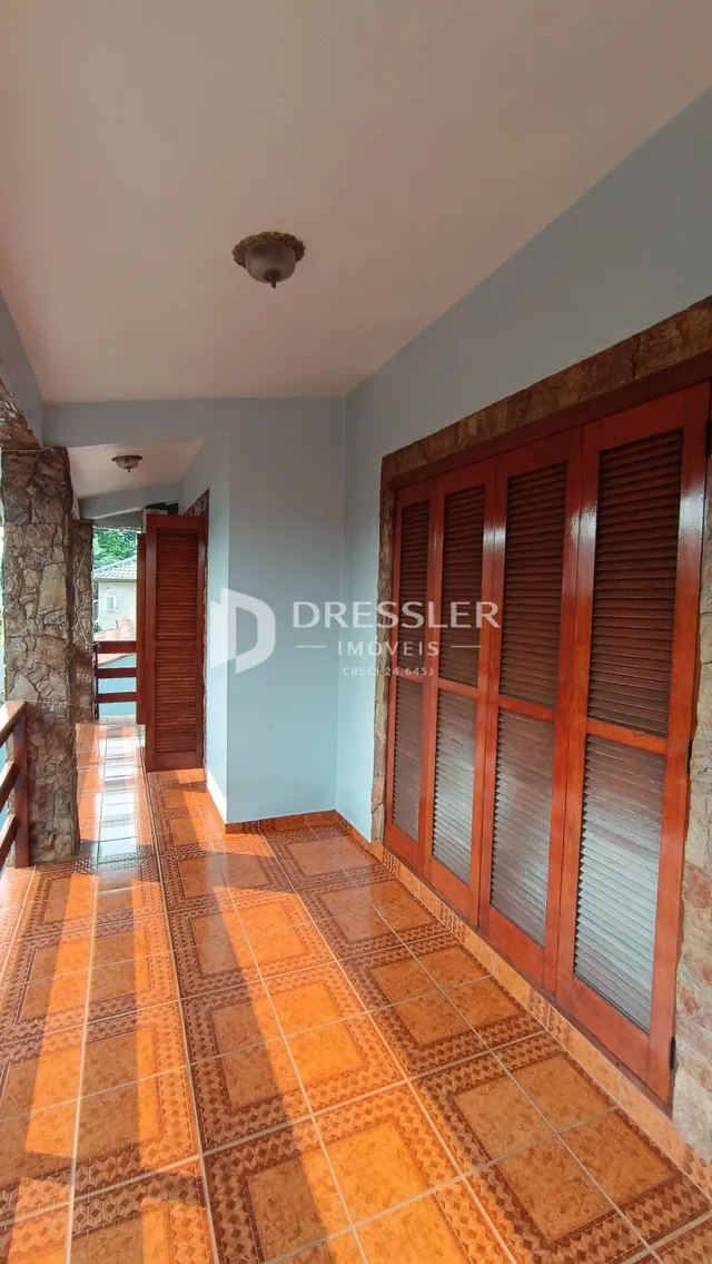 Corredor interno com piso de cerâmica e portas de madeira.