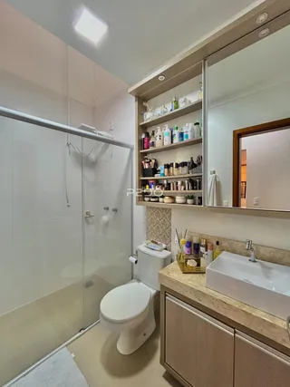 Foto de um banheiro moderno com box de vidro e bancada clara.
