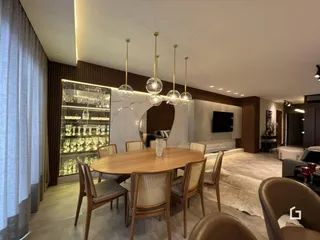 Imagem de uma sala de jantar com mesa de madeira e cadeiras de vime.