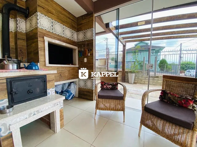 Sala de estar com painel de madeira e acesso a uma área externa com vista.