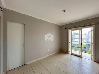 Interior de uma sala com piso de cerâmica e porta branca.