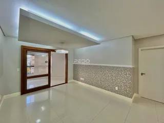 Sala de estar com piso de cerâmica e parede decorada em um imóvel no Brasil.