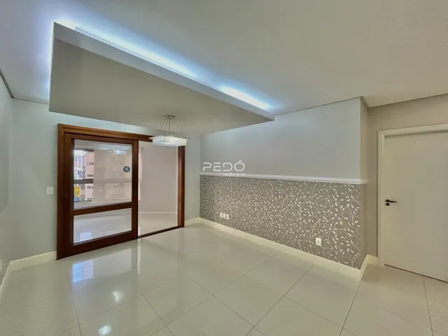 Sala de estar com piso de cerâmica e parede decorada em um imóvel no Brasil.